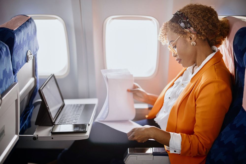 Travel manager reviewing reports while on an airplane