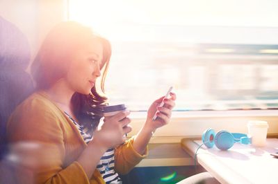 woman drinking coffee reading phone.jpg