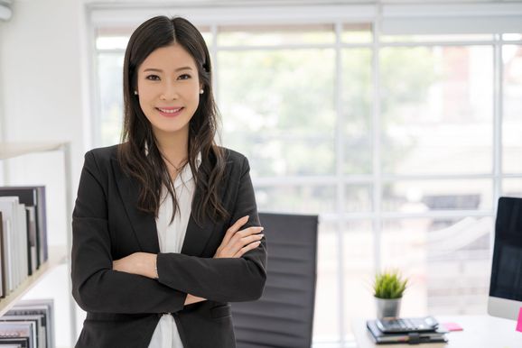 woman_in_blazer_smiling_at_camera_with_arms_crossed.jpg